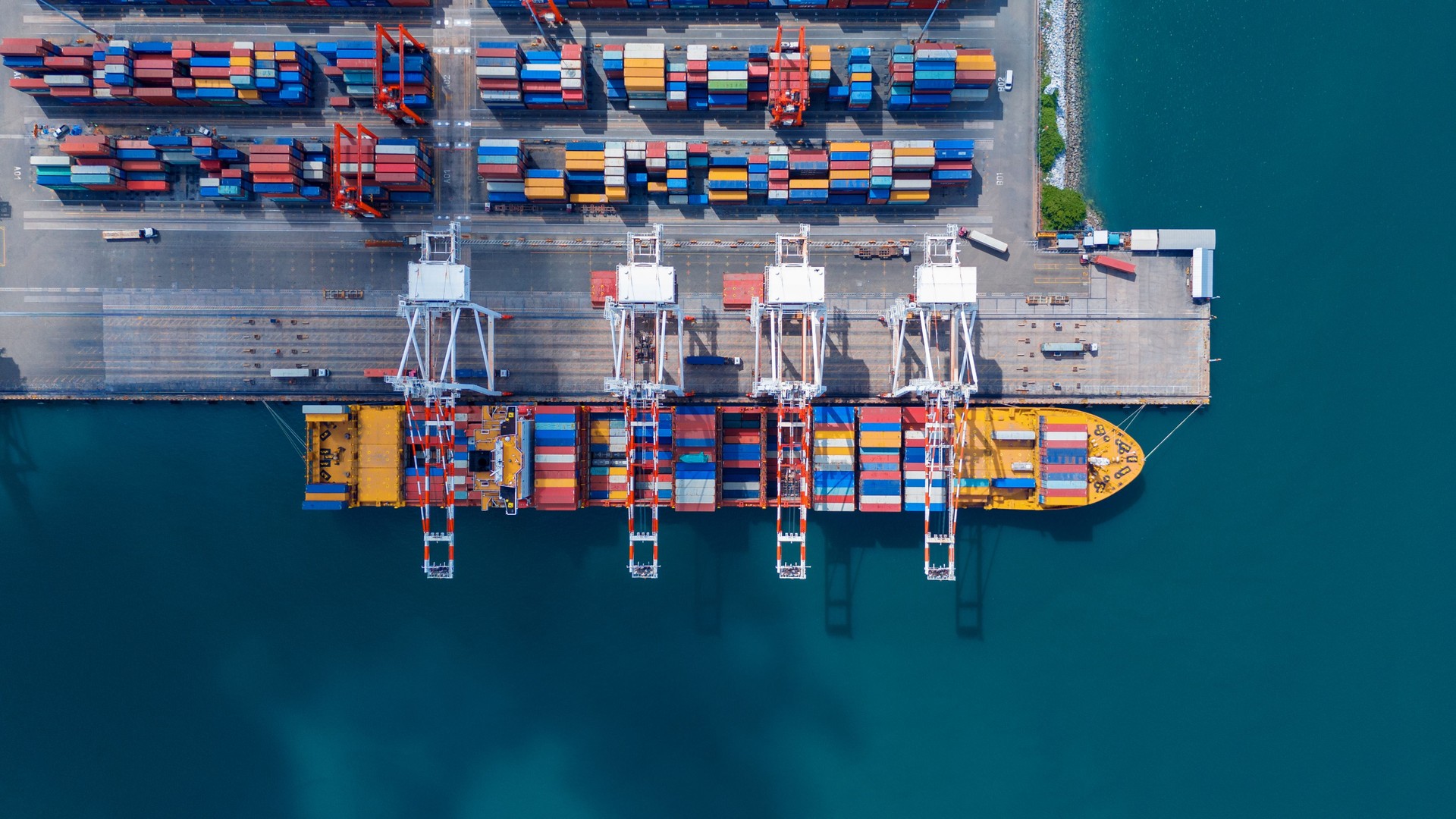 crane loading cargo container from truck to container ship in the international terminal logistic sea port concept freight shipping by ship. industry transportaion