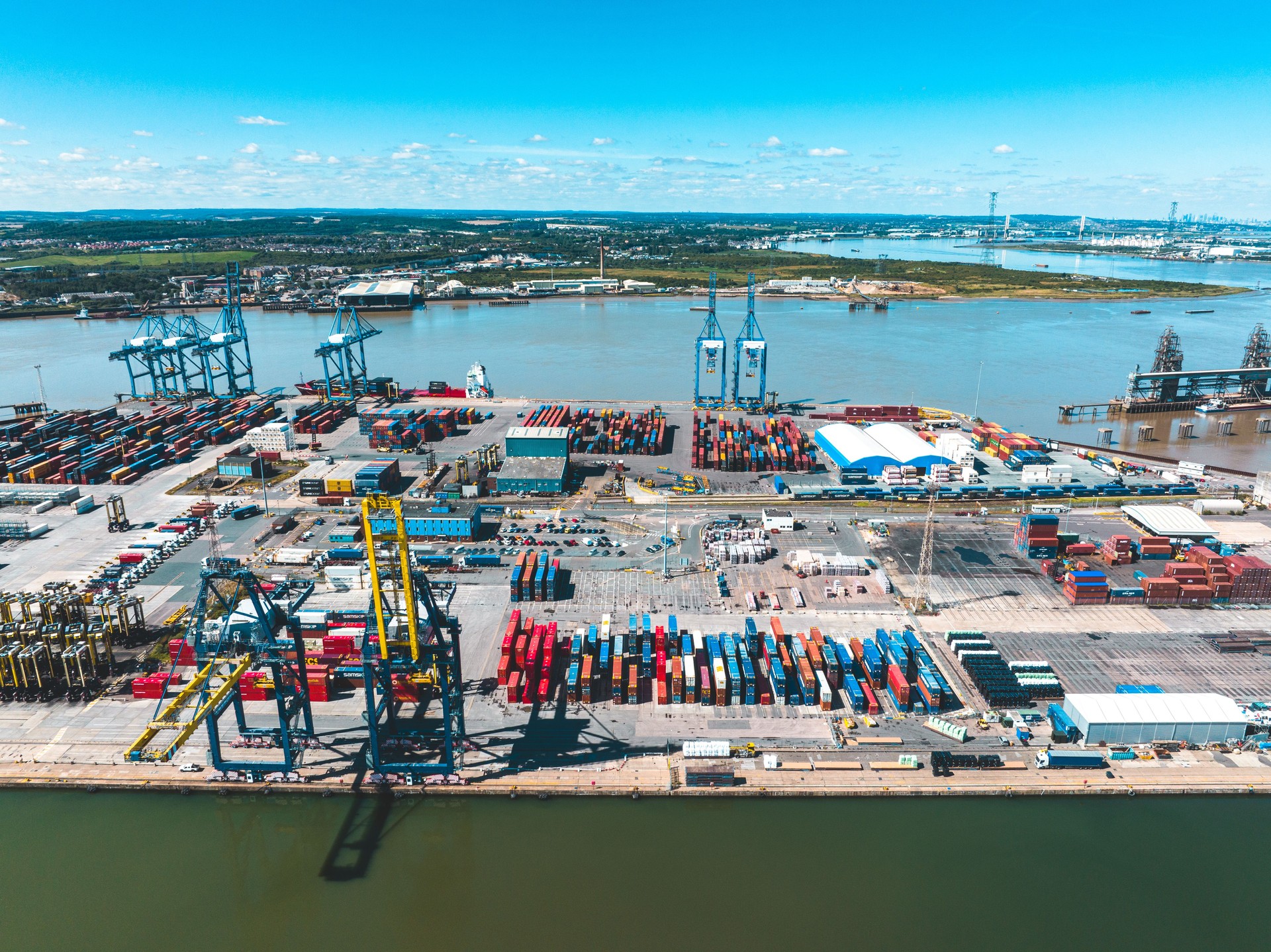 Cargo port with cranes loading containers on a sunny day